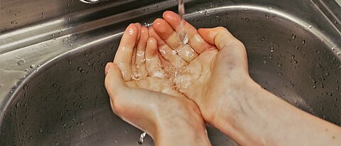 Eine Person wäscht sich die Hände.