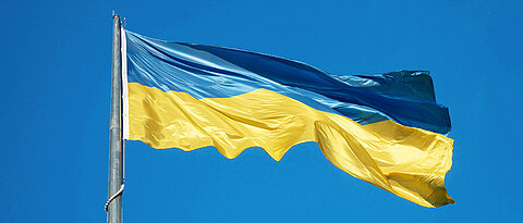 Ukrainische Flagge im Wind vor blauem Himmel.